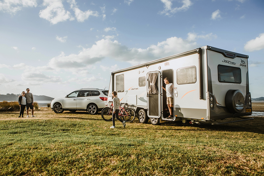 A family setting up their caravan beside the water