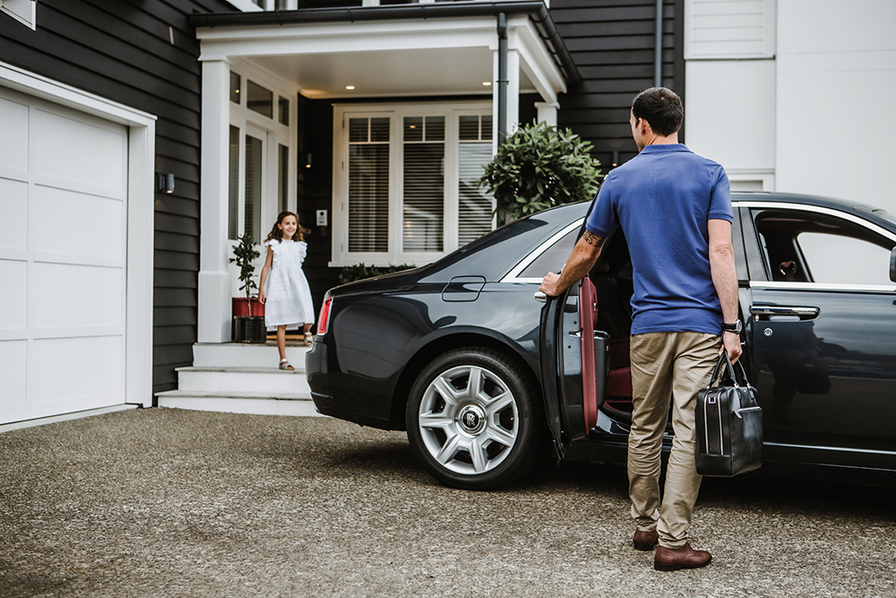 An owner arriving home in a prestige car